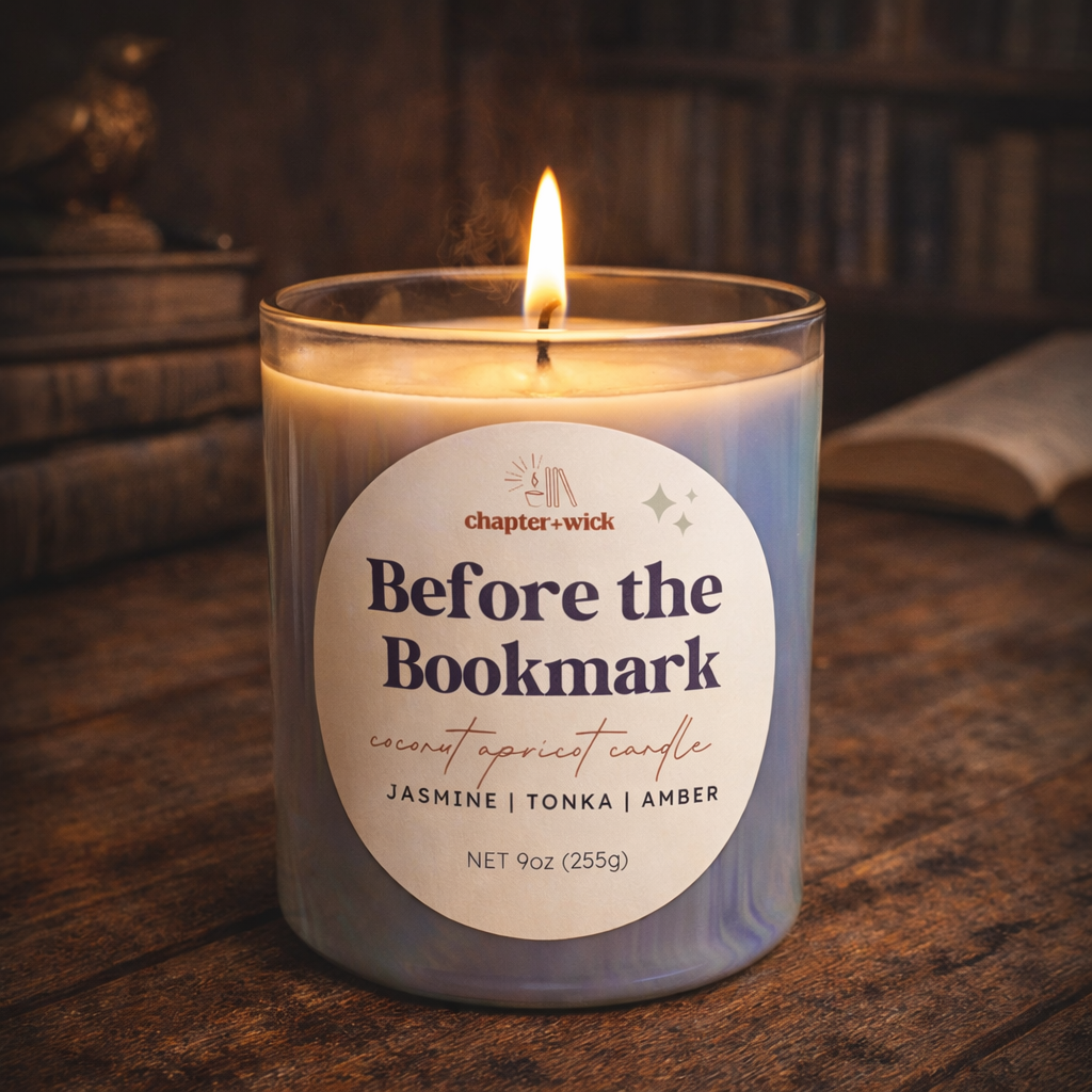 Candle labeled 'Before the Bookmark' on a wooden surface with a bookshelf in the background