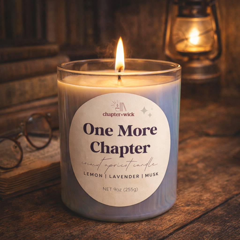 Candle labeled 'One More Chapter' with a label detailing scents on a wooden surface.