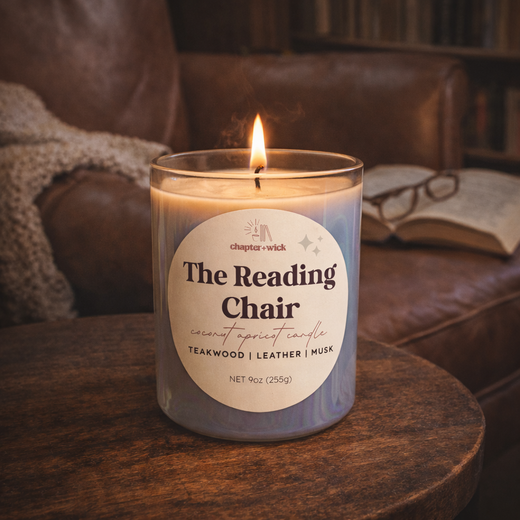 Candle labeled 'The Reading Chair' on a wooden surface with a cozy background